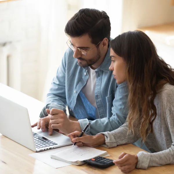 Un couple examine ses finances, discutant des prêts sur salaire et de la gestion de leur budget.