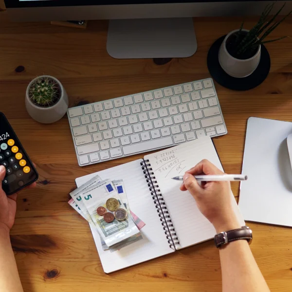  Man calculating finances with a calculator and pen, focused on a loan simulator.